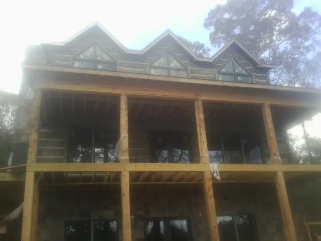 Dormers and porch framing on a large log home under construction — Roof Coating work by our crew in Homer Glen